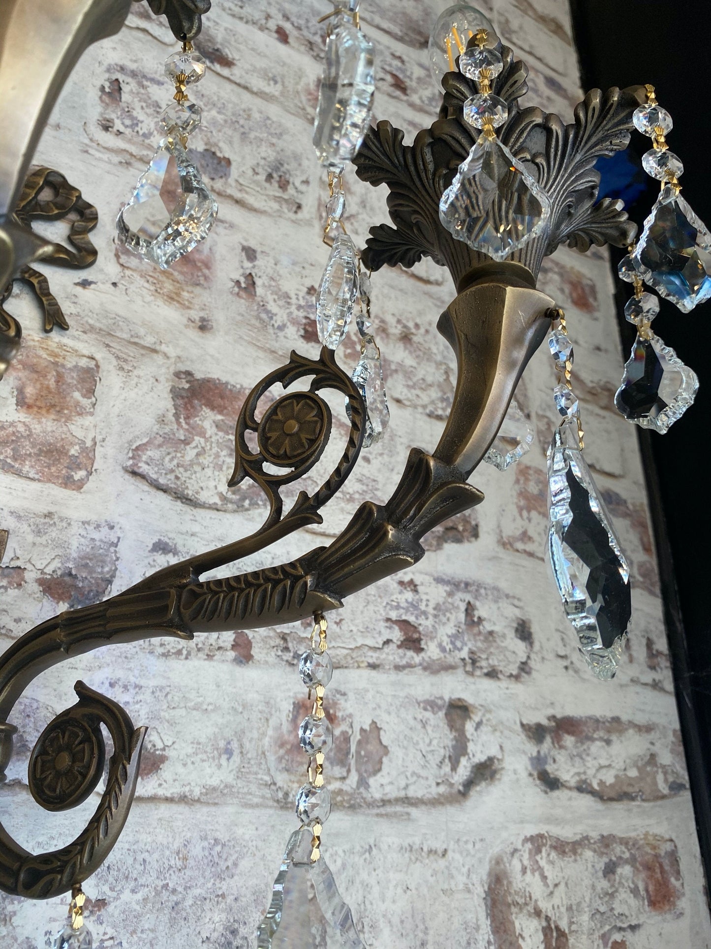 Detailed view of handmade brass arms wall sconce with crystals leaf