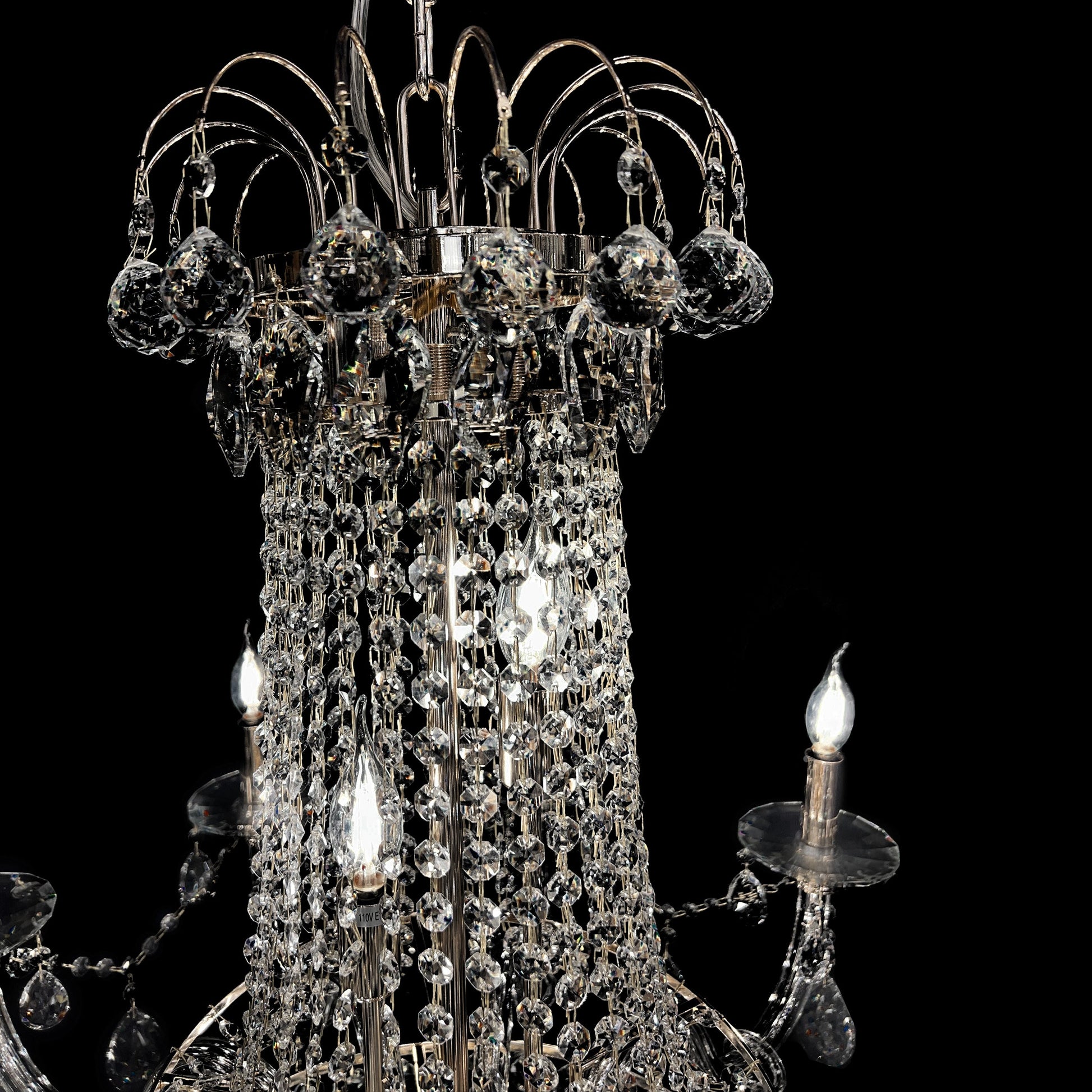 Close-up of precision-cut crystal strands and chrome accents in a luxury chandelier.