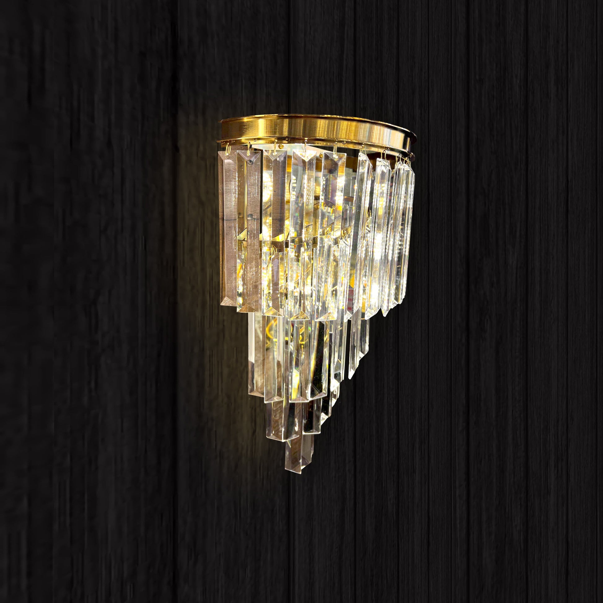 Decorative wall light fixture with crystal accents on a dark wooden background