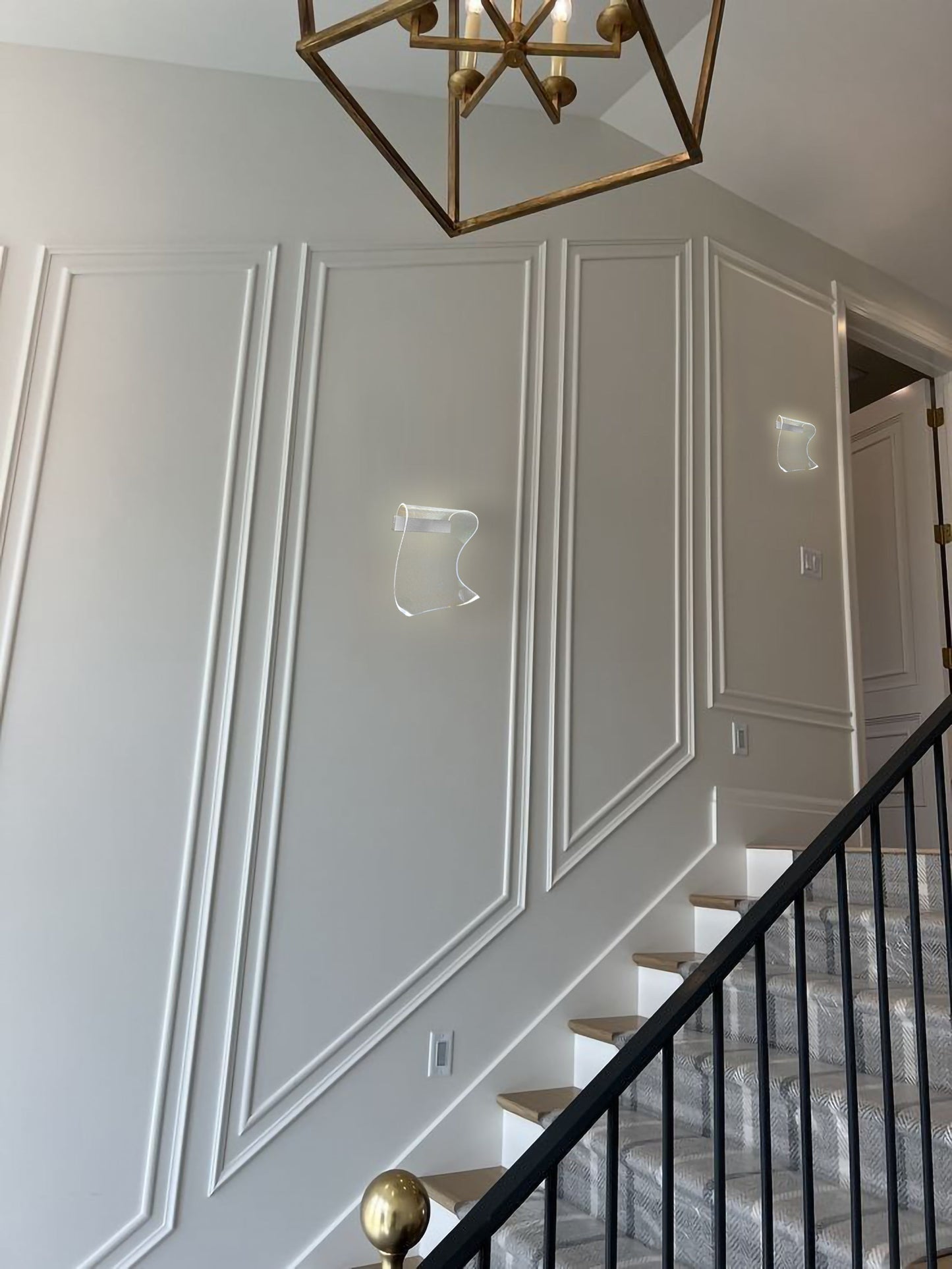 Chrome curved mesh LED sconce installed in hallway