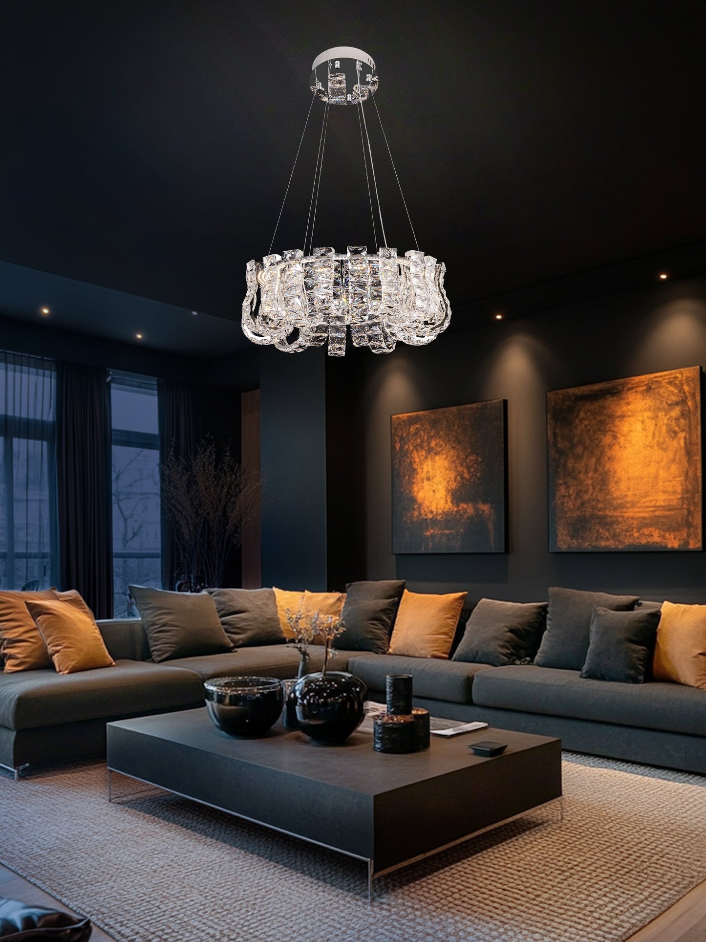 Round chrome crystal chandelier glowing warmly in a modern living space with soft ambient lighting.
