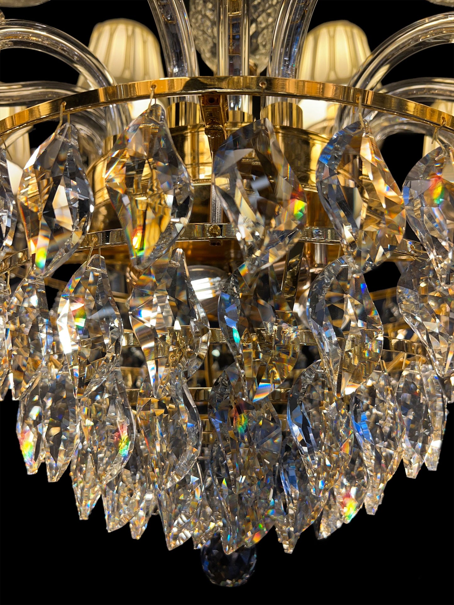  Close-up of precision-cut crystal drops reflecting warm gold tones and light