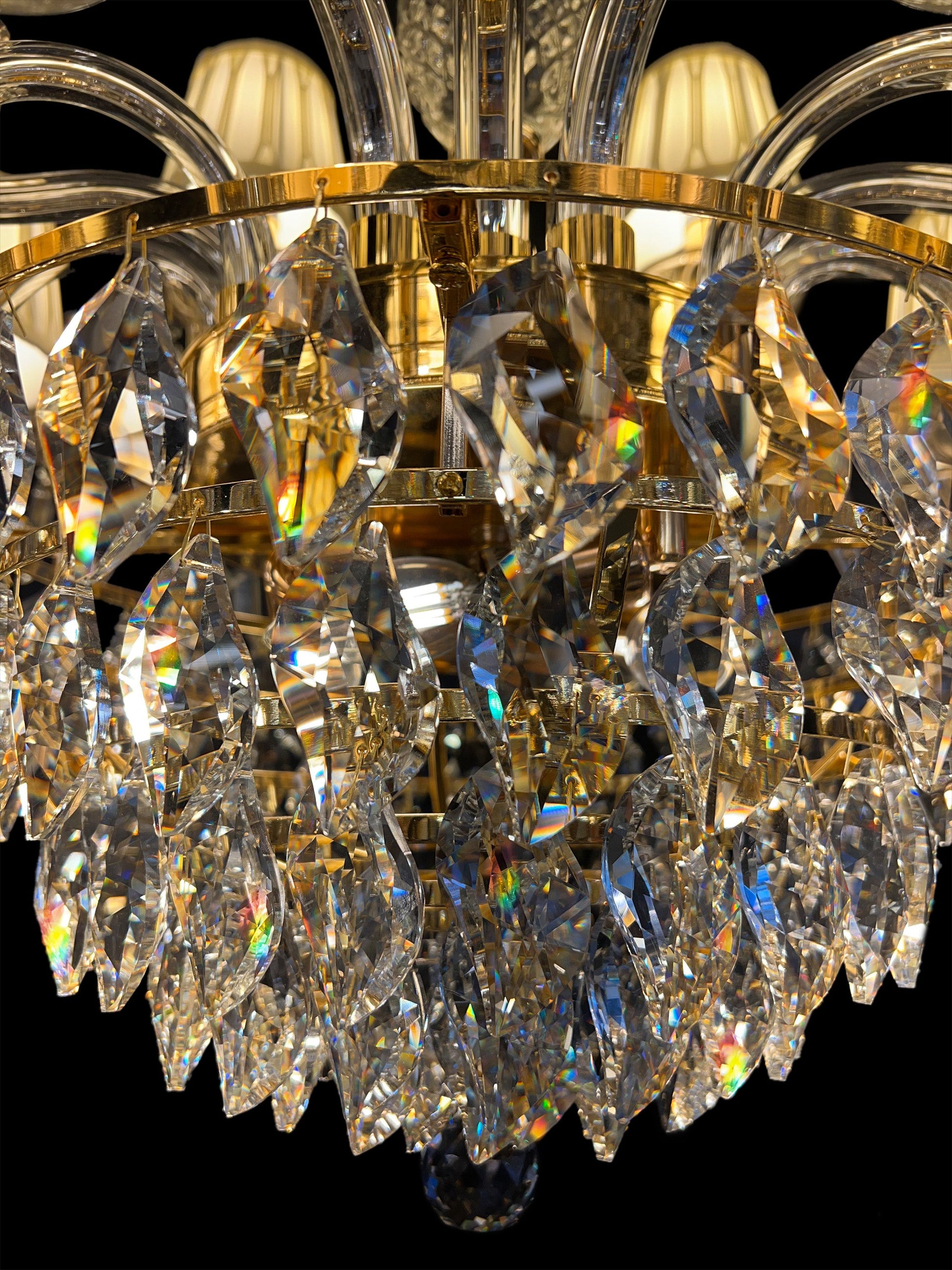  Close-up of precision-cut crystal drops reflecting warm gold tones and light