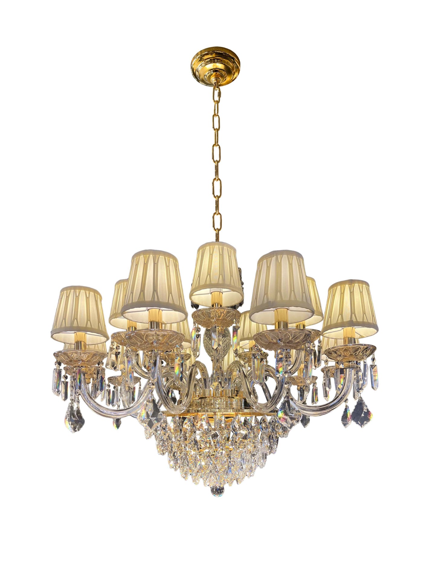 Full view of dimmable gold crystal chandelier with fabric shades and classic tiered design on white background