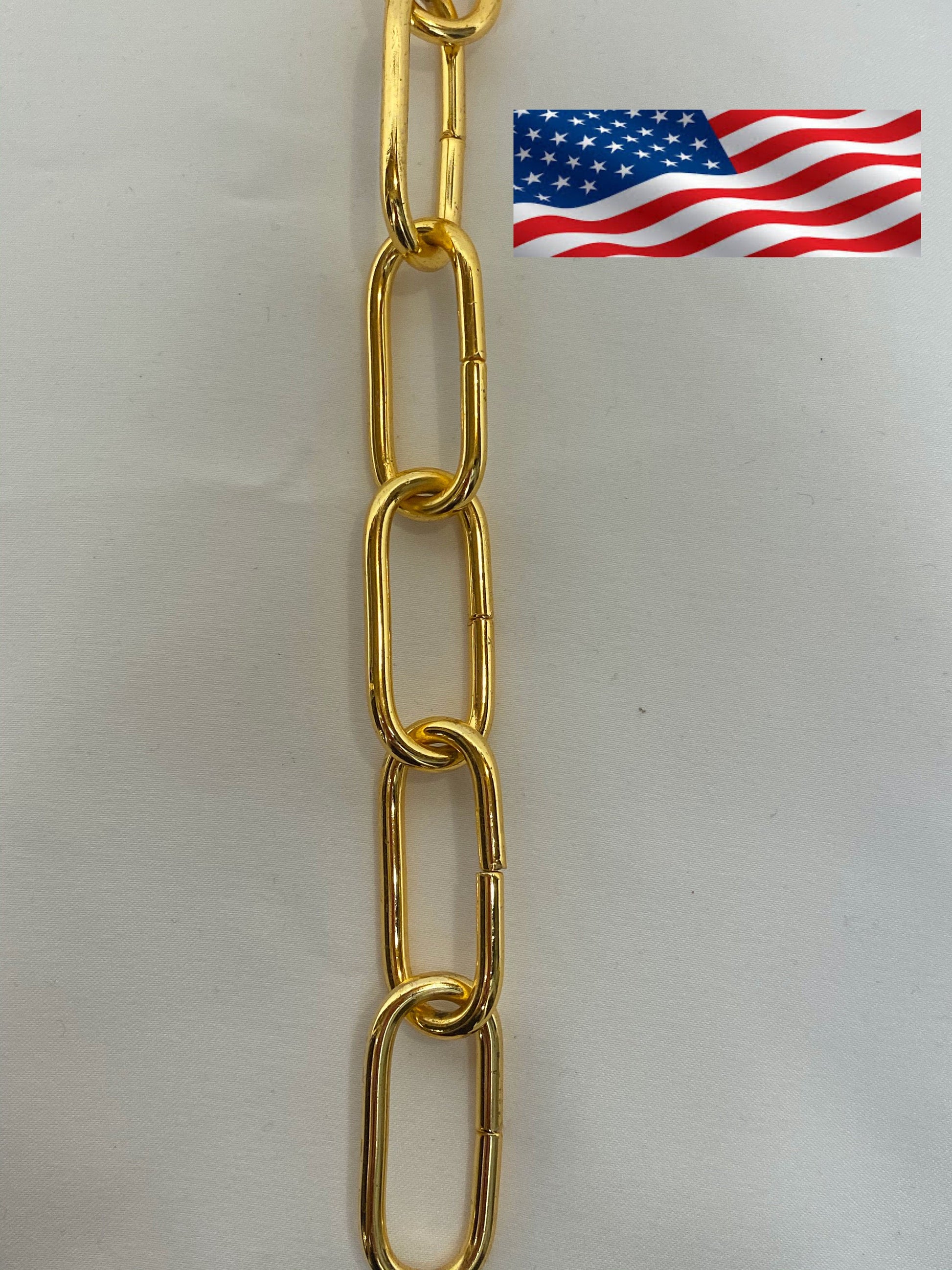 A section of gold-plated iron chain showing the links with a flag of the United States in the corner.
