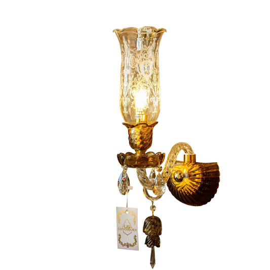 A gold-colored Italian crystal and glass wall sconce with an etched glass hurricane shade, twisted glass arms, and sparkling crystal accents.