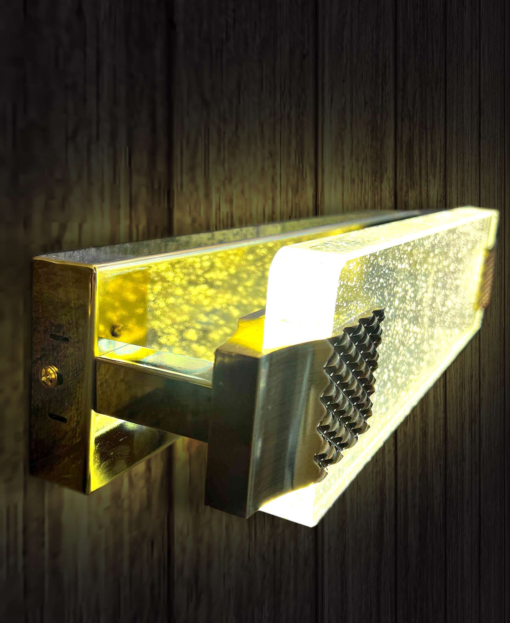 Decorative wall light fixture with a metallic finish on a wooden background