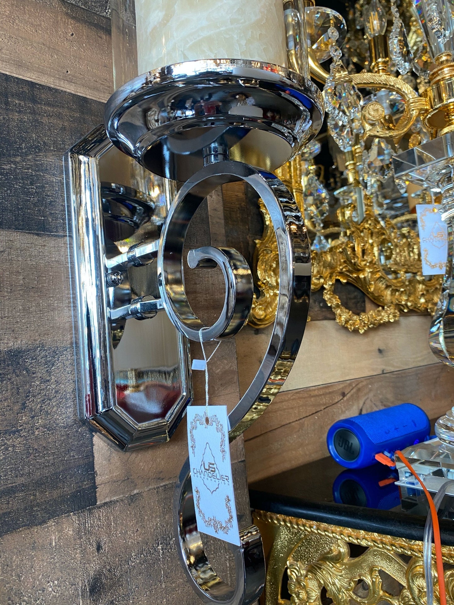 Decorative metal wall sconce with a tag on a wooden surface