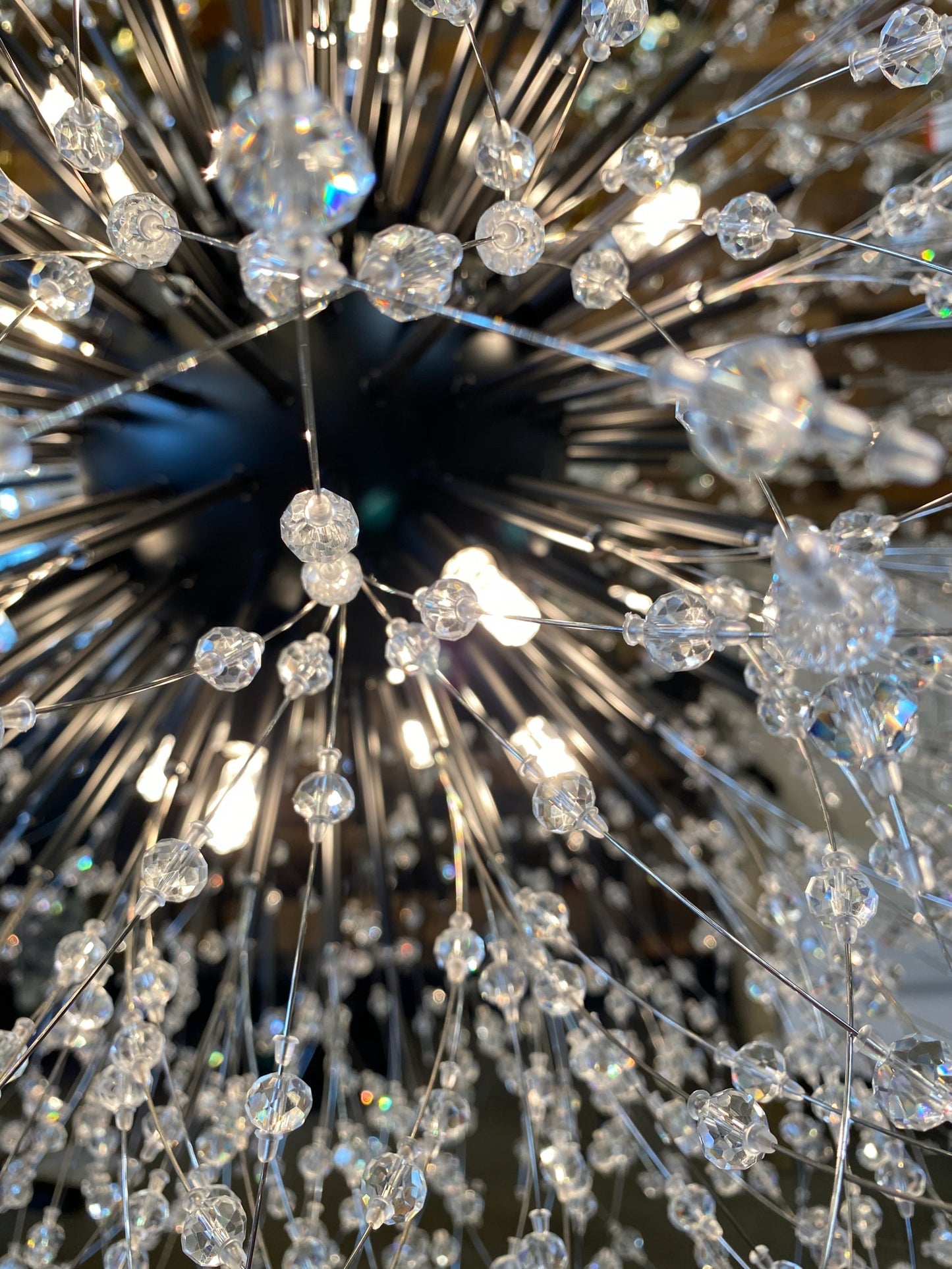 Detailed close-up of black starburst chandelier with sparkling crystals