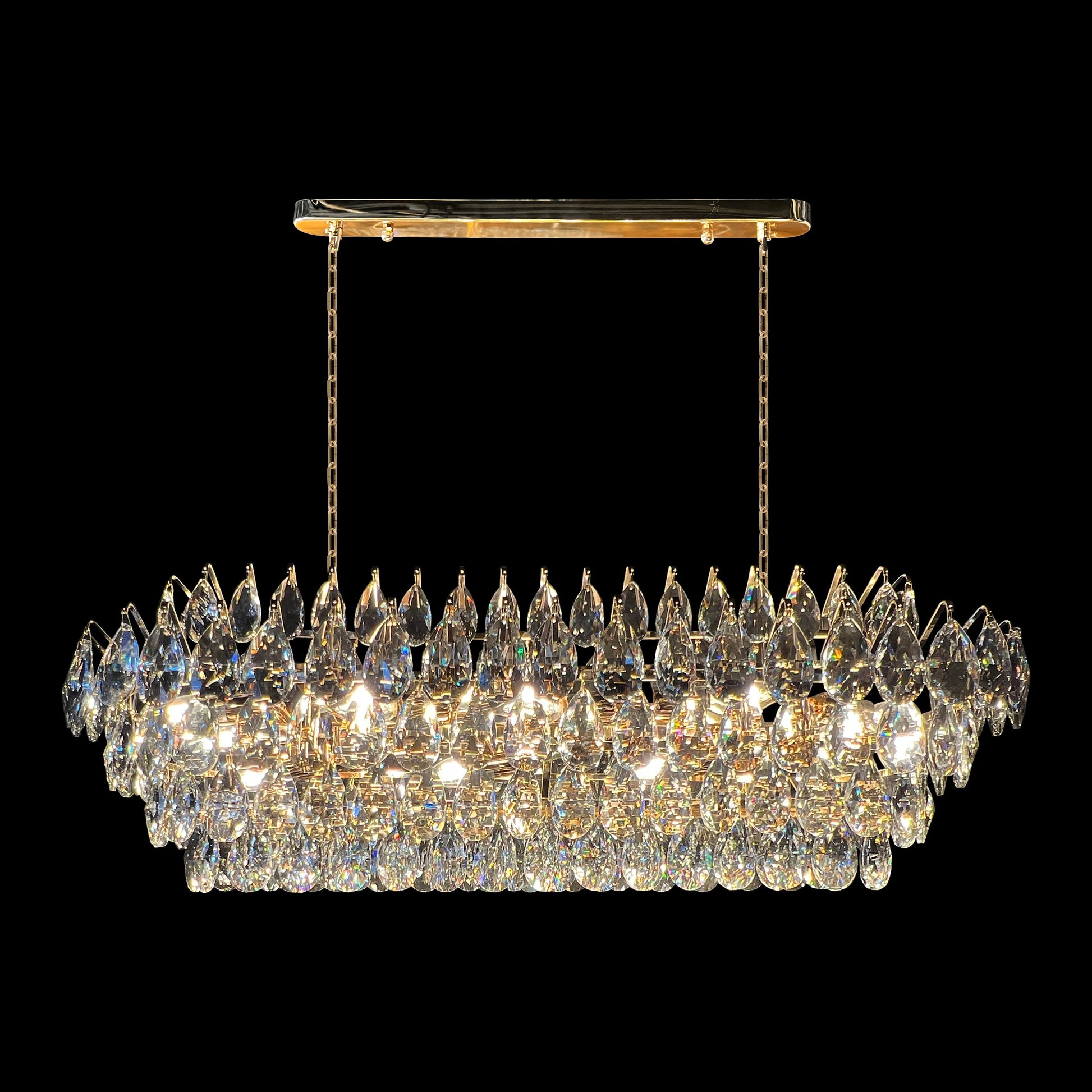 Champagne gold rectangular crystal chandelier with teardrop K9 crystals and empire-style linear design on a black background.
