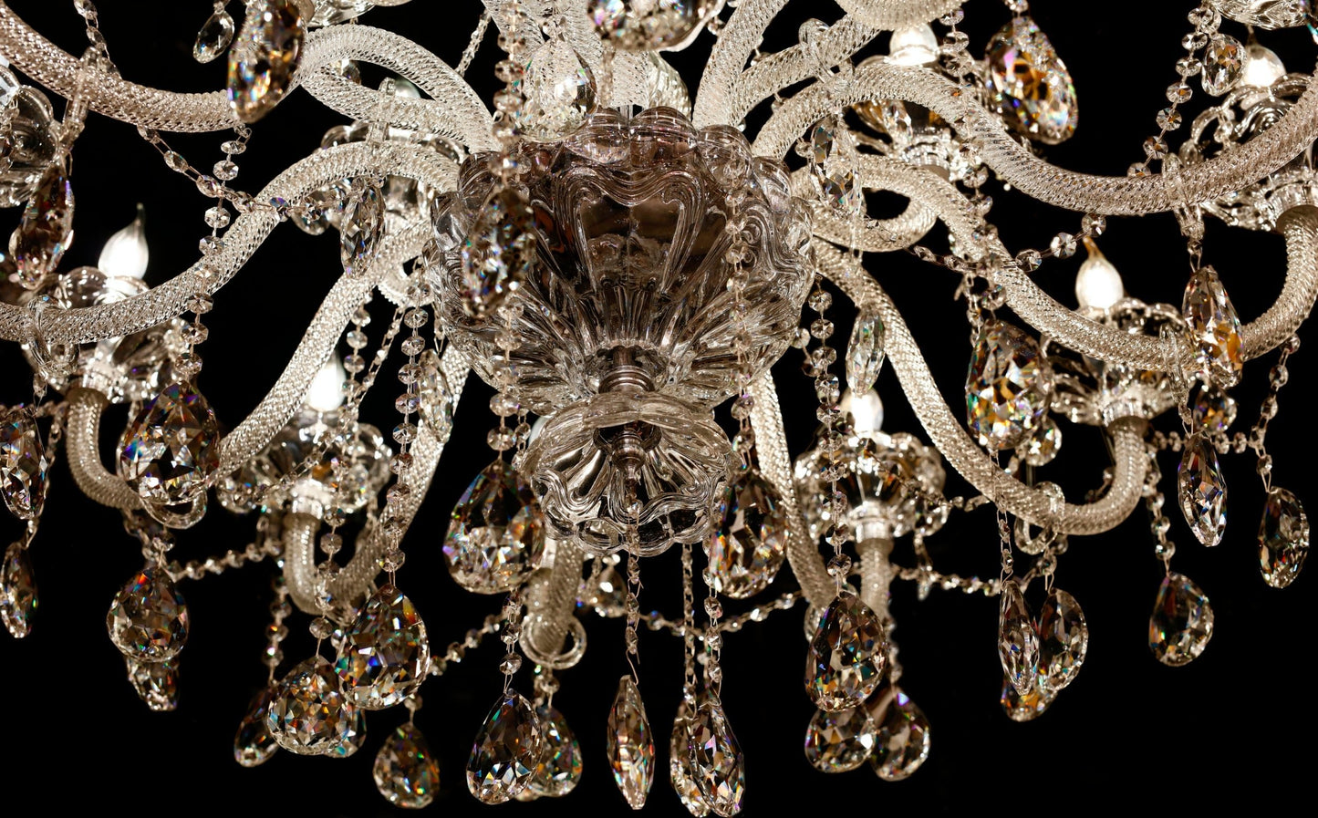 Detailed view of the chandelier’s chrome arm and crystal accents.