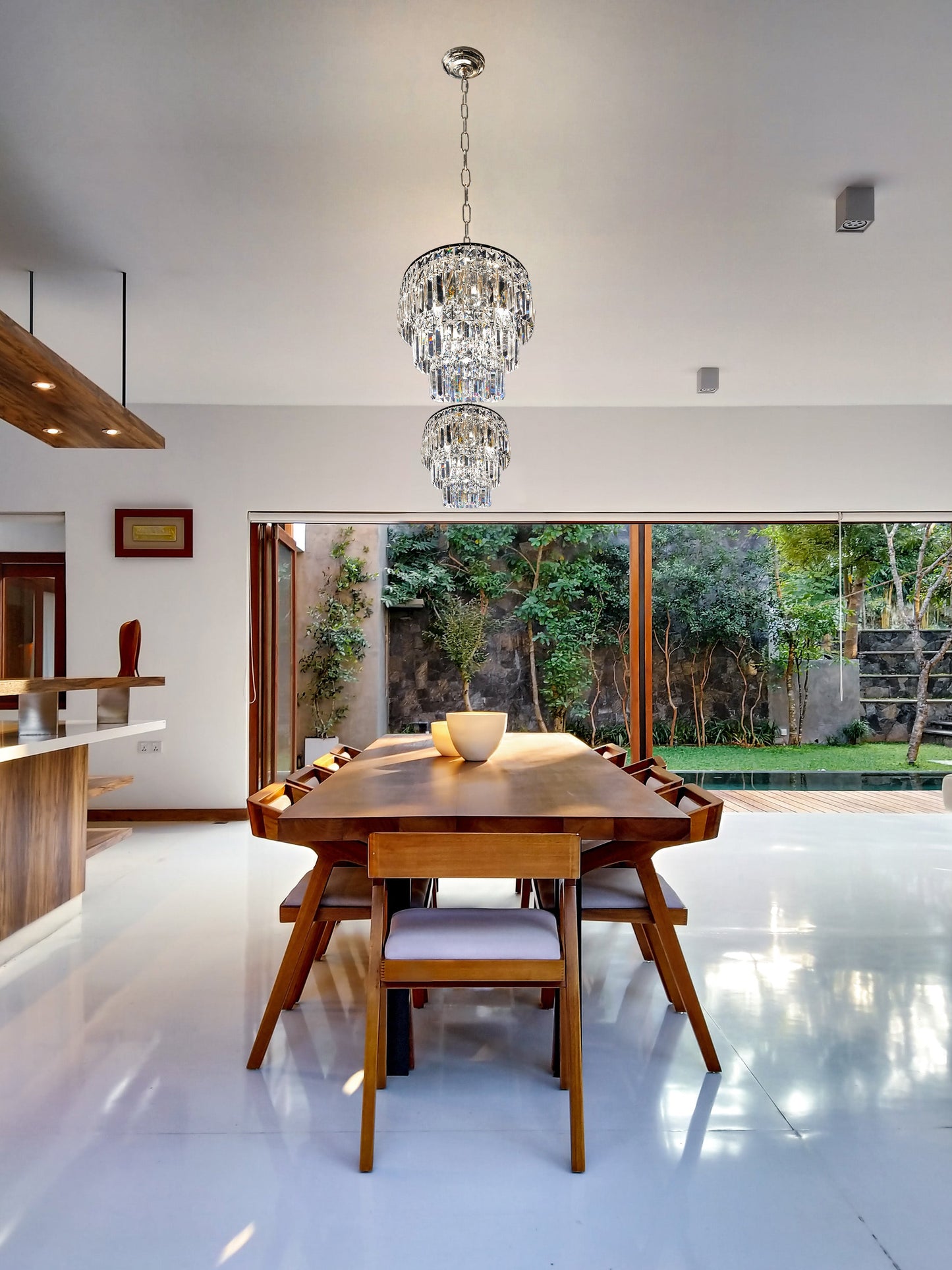 Tiered chrome chandelier lighting above elegant dining table