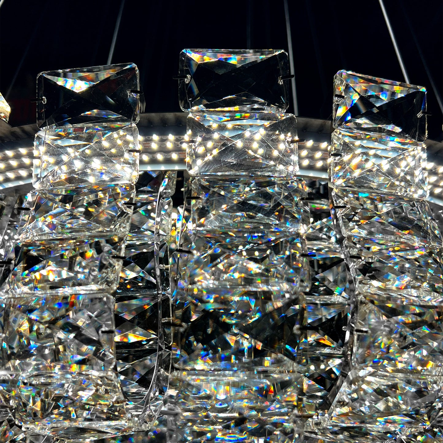 Closeup of luxury K9 crystal chandelier showing intricate silver frame and reflective crystal details.