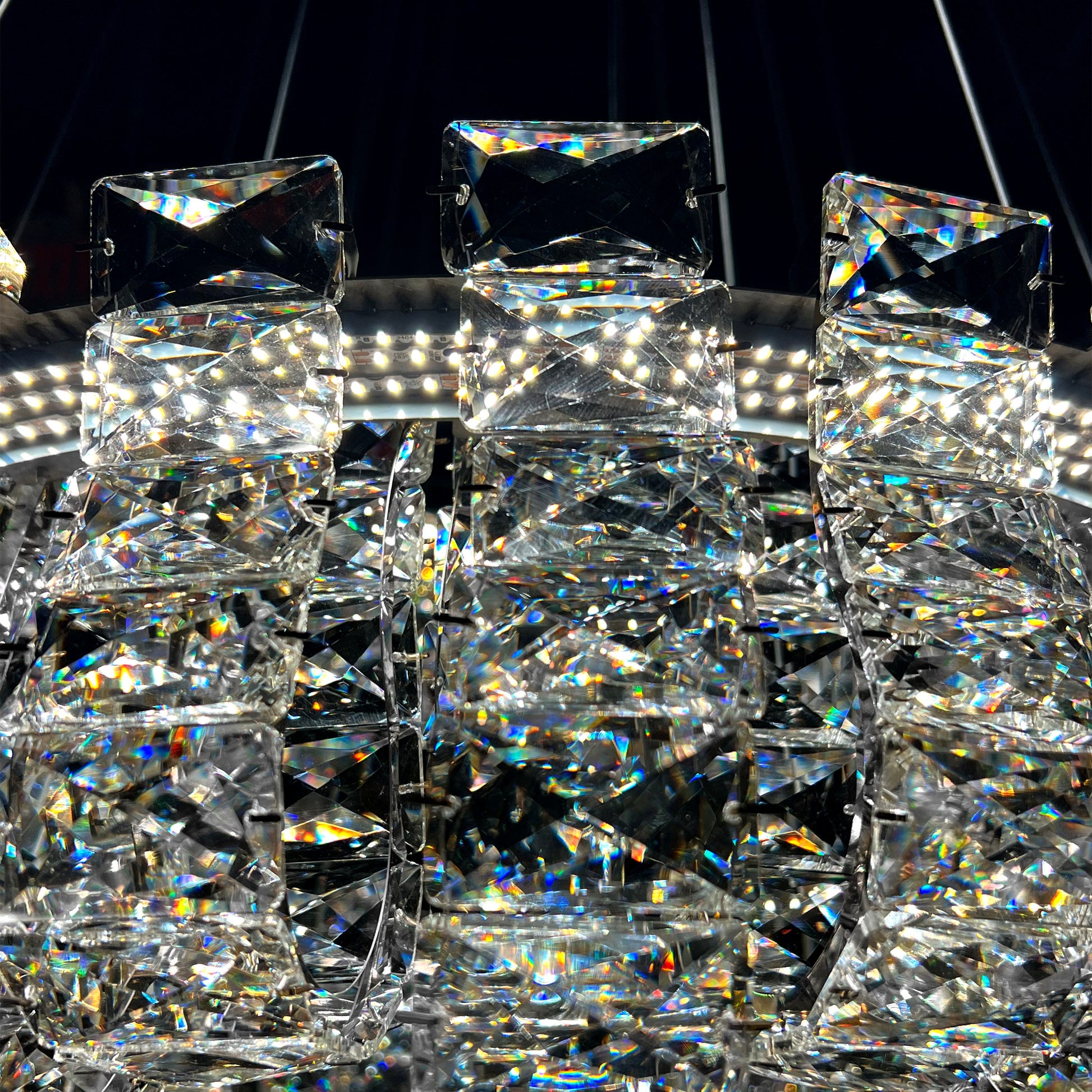 Closeup of luxury K9 crystal chandelier showing intricate silver frame and reflective crystal details.