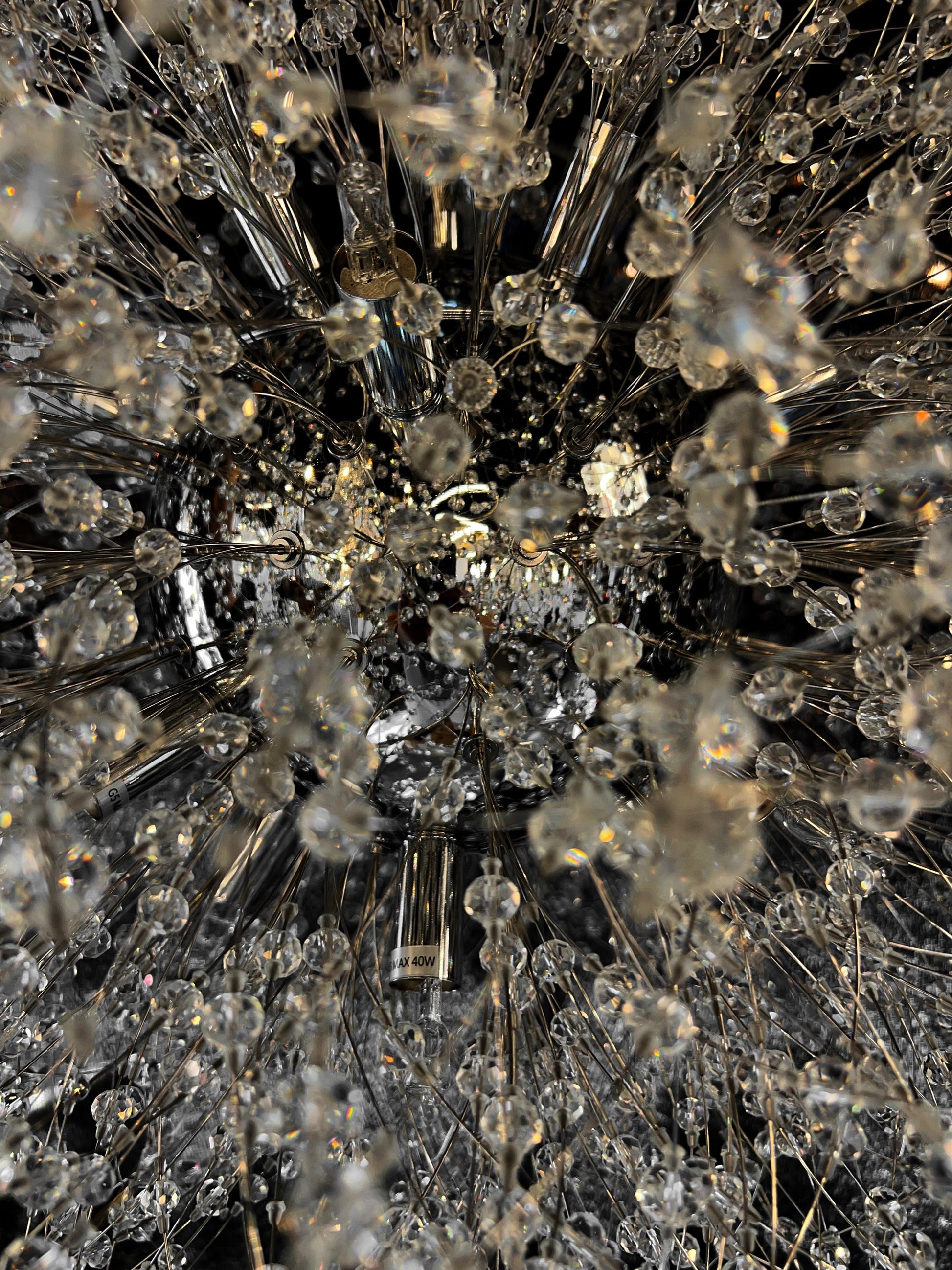 Precision-cut crystal branches detail on modern chrome chandelier