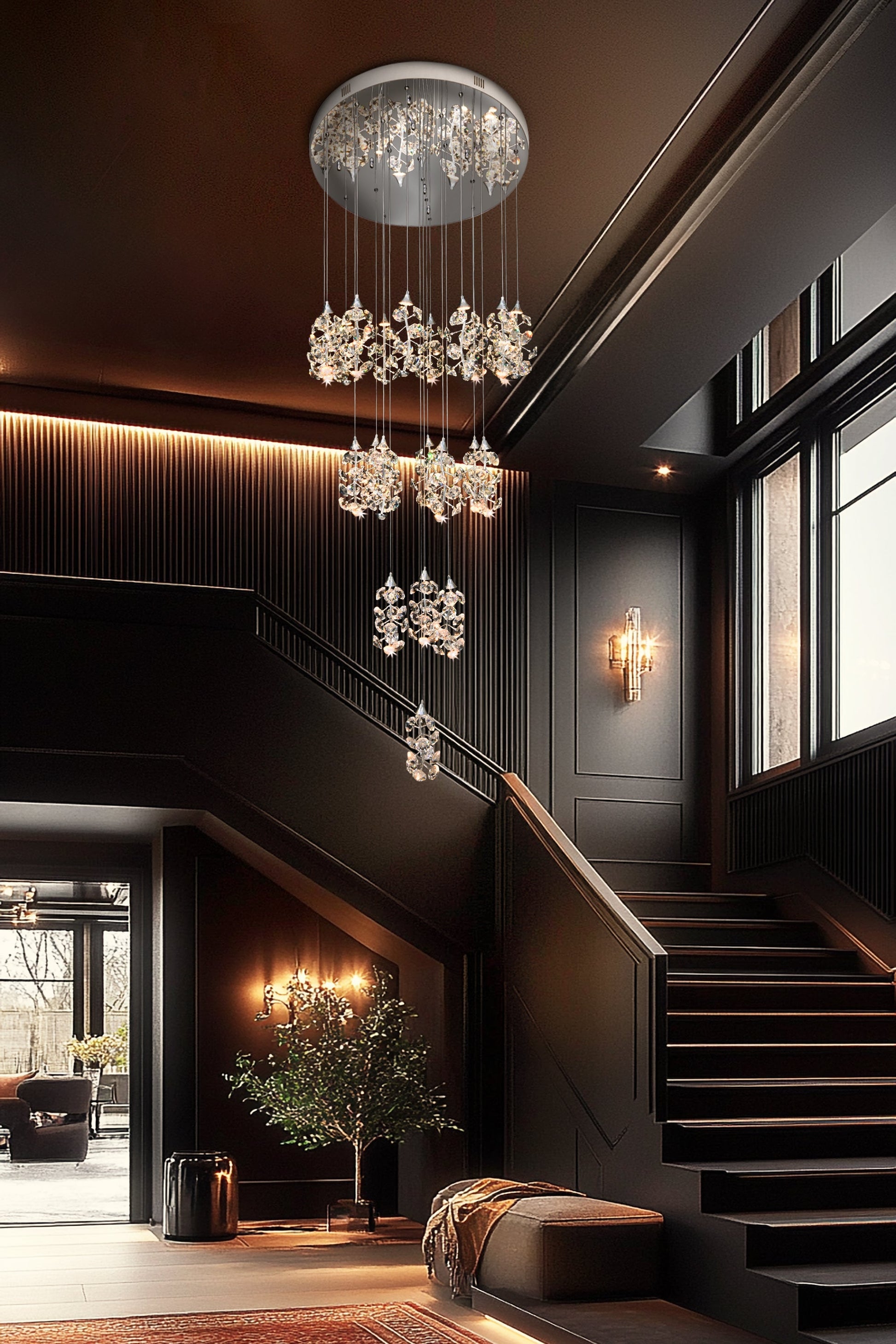 Tall LED cascading crystal chandelier lighting a modern foyer and staircase