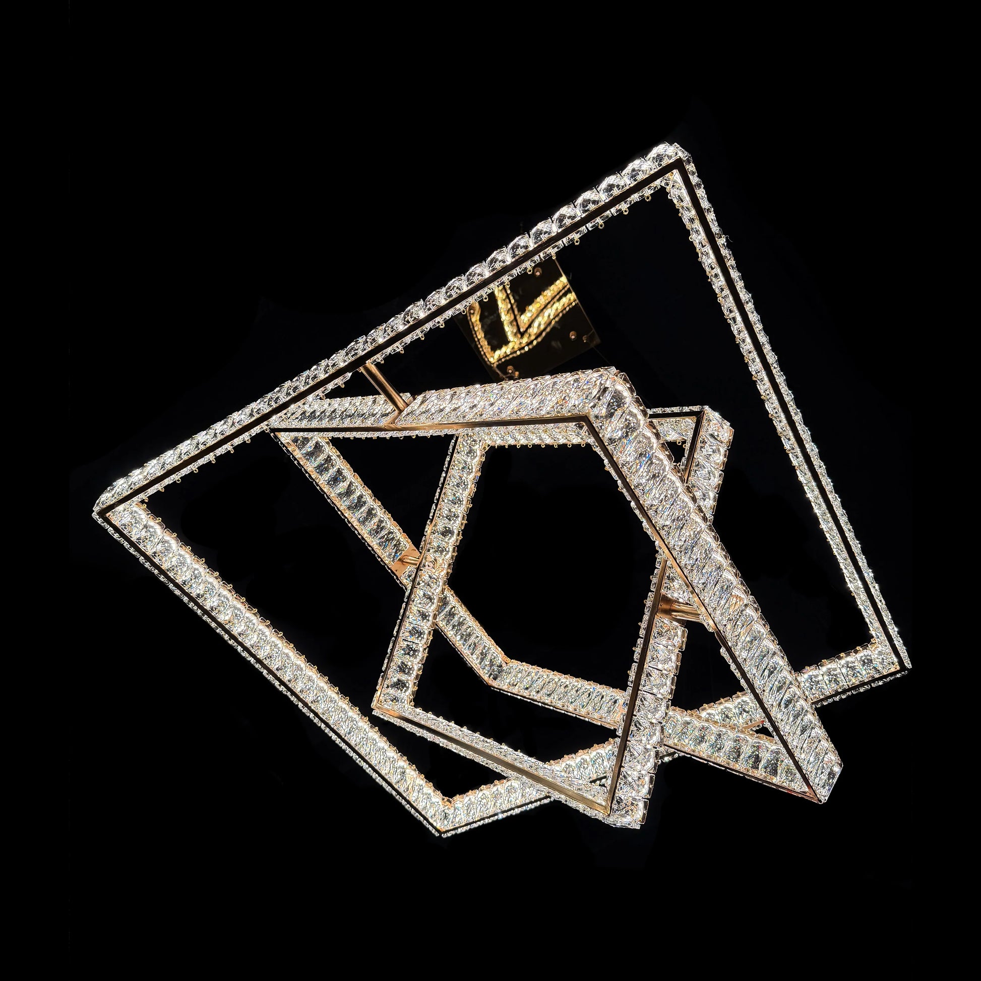 Underside view of the illuminated geometric square tiers of the modern gold chandelier.