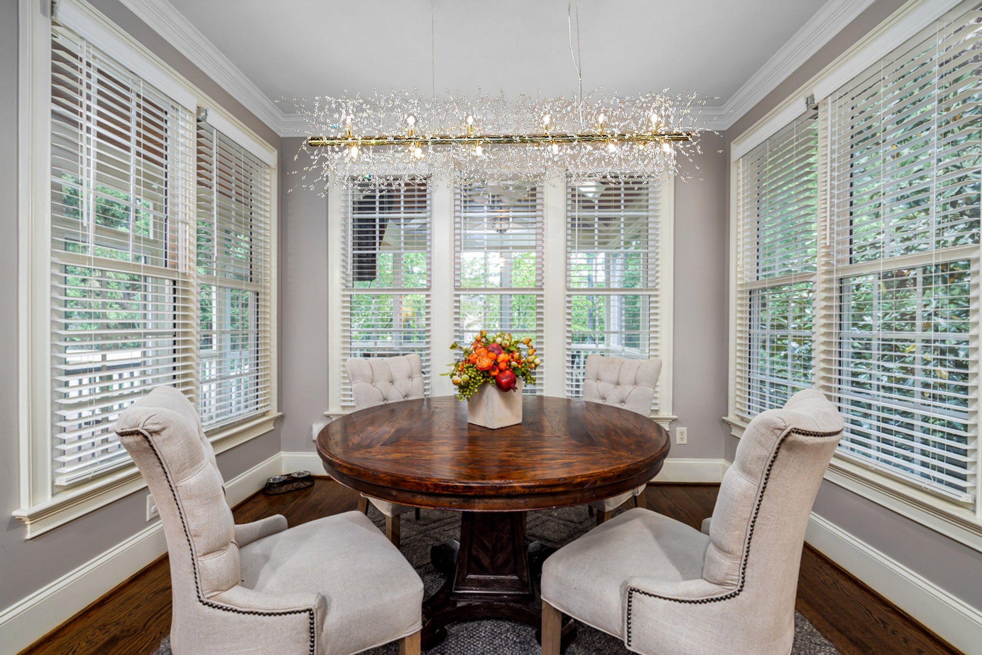Linear gold crystal chandelier illuminating modern dining room
