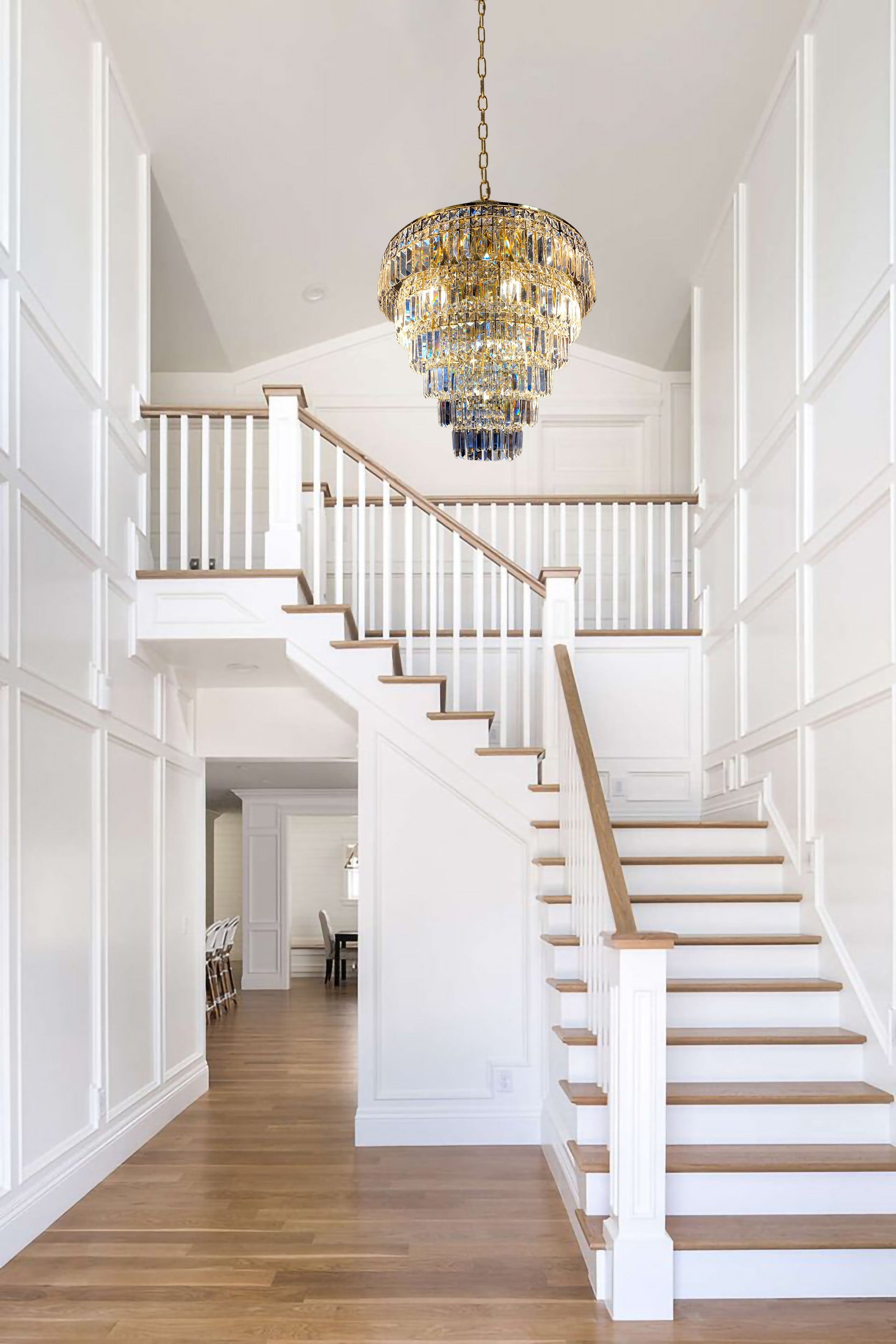 Modern gold tiered crystal chandelier illuminating staircase interior