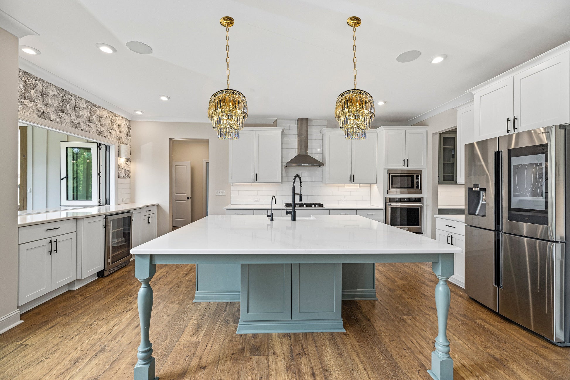 Polished gold chandelier illuminating kitchen island area