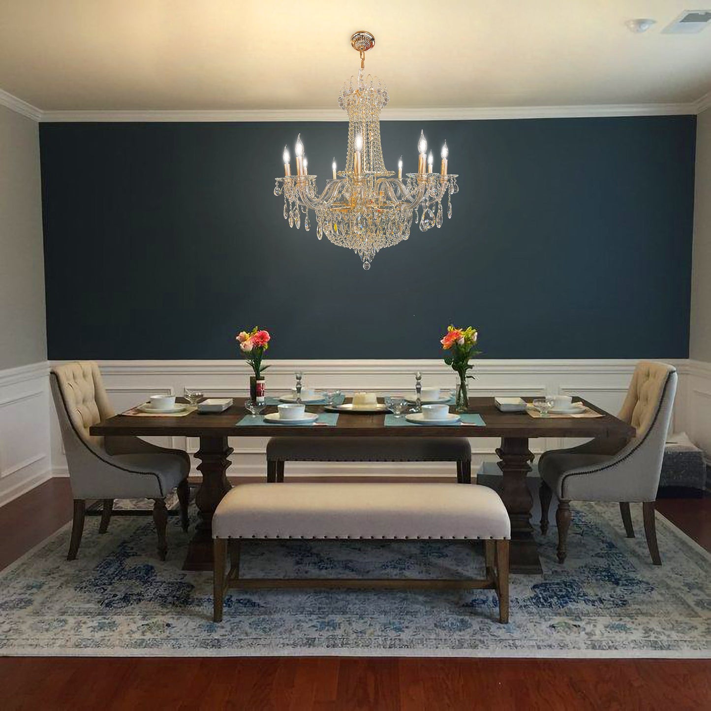 Elegant gold crystal chandelier above classic dining table with modern wall paneling