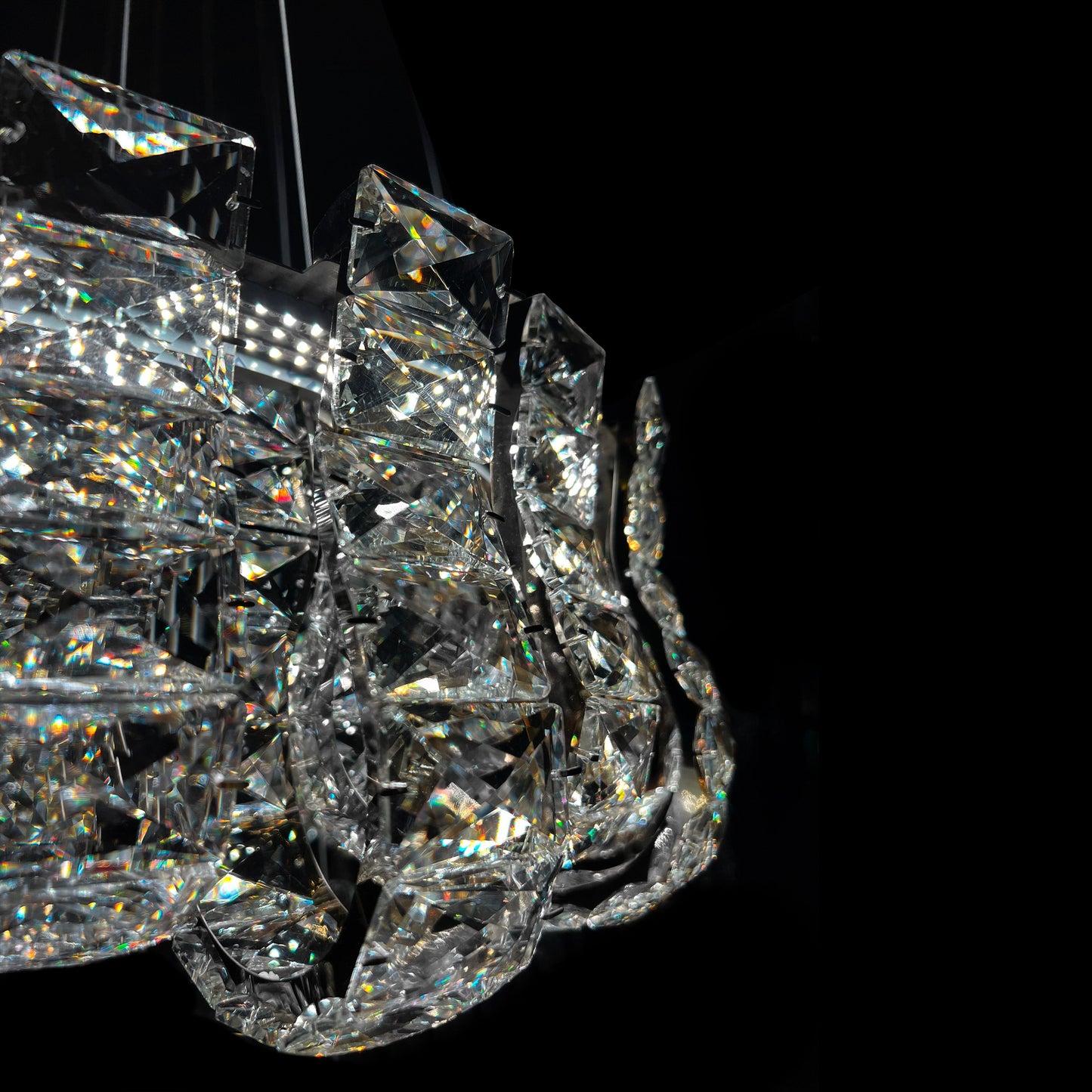 Closeup of premium K9 crystal blocks on luxury chrome chandelier, highlighting clarity and reflective sparkle.