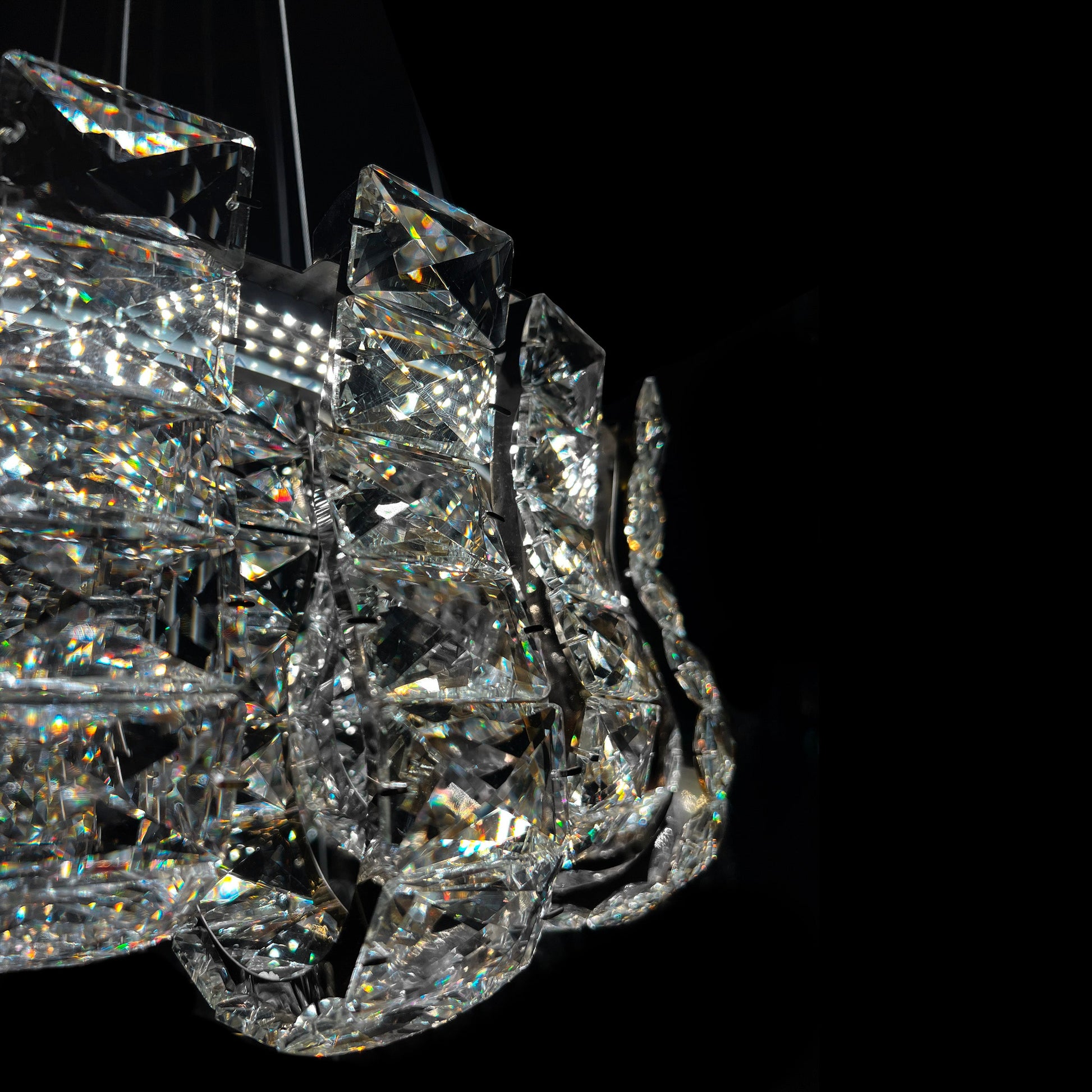 Closeup of premium K9 crystal blocks on luxury chrome chandelier, highlighting clarity and reflective sparkle.