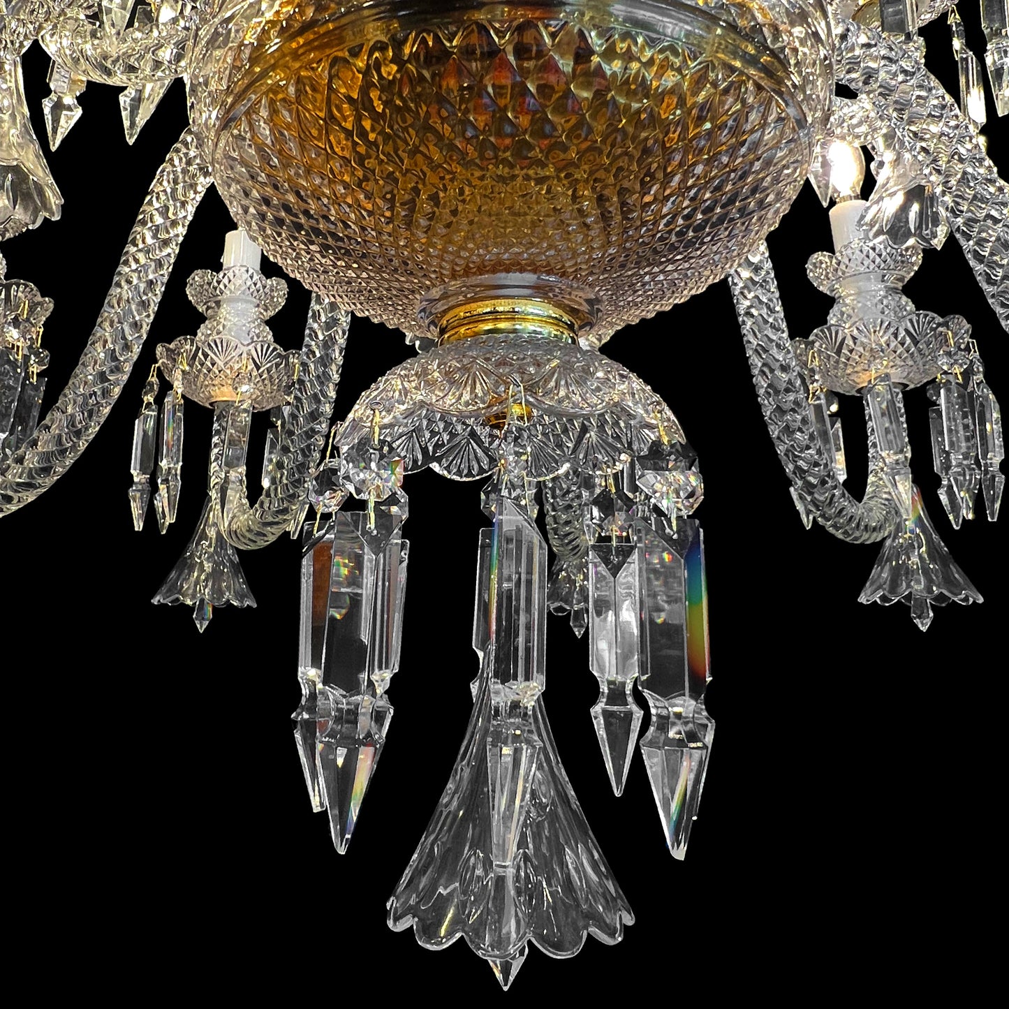 Bottom view of a luxury gold and crystal chandelier showing intricate cut-glass details and hanging crystal drops.